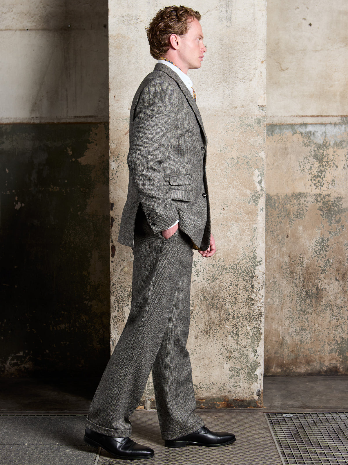 Tweed-Anzug Dark Grey mit Fischgrät aus Moon Tweed, Seitenansicht im Gehen — John Crocket
