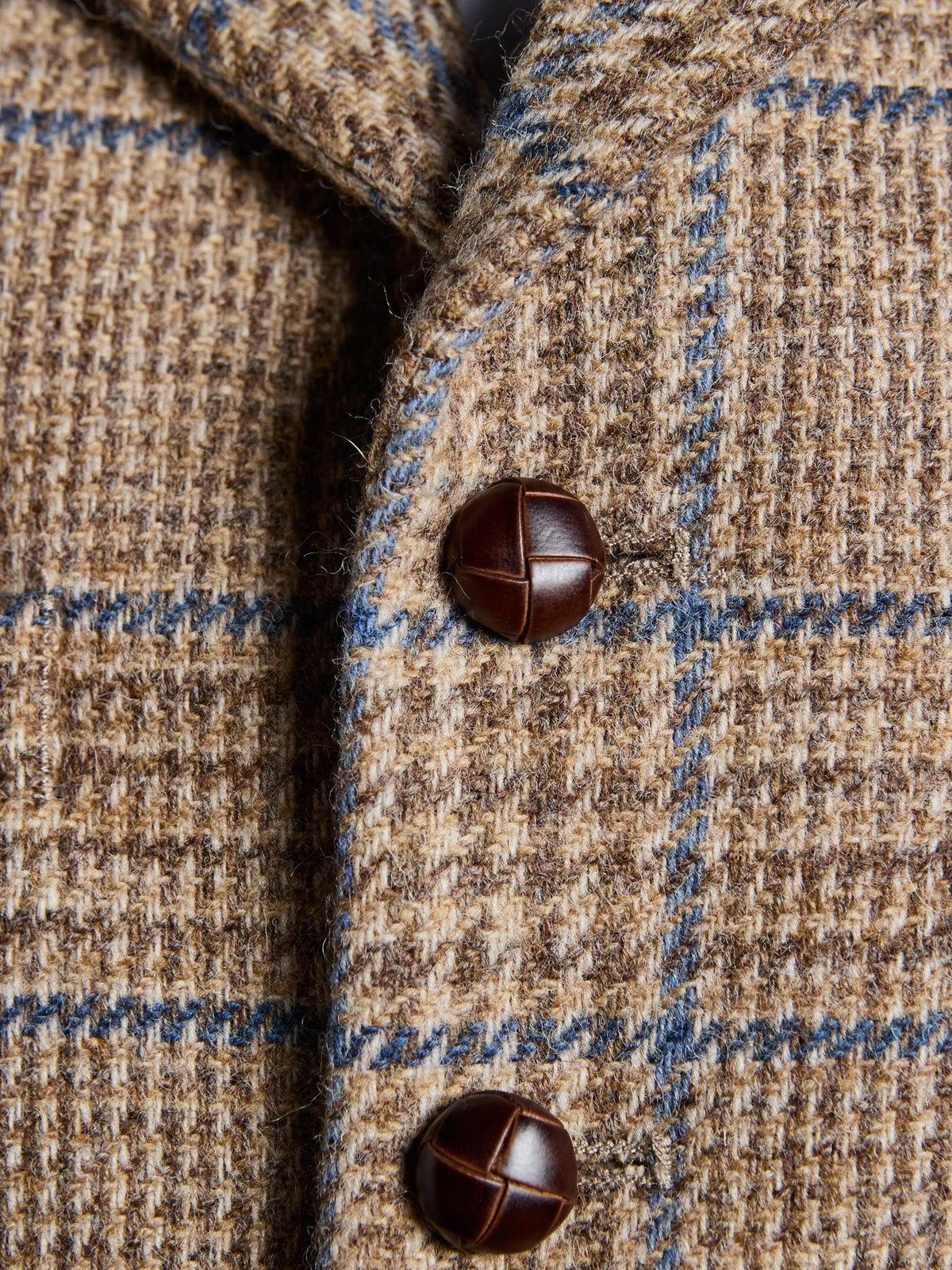 Tweed-Weste aus Magee Tweed in Sand, Detail von Revers, Lederknöpfen und Prince-of-Wales-Karo mit blauem Überkaro – John Crocket