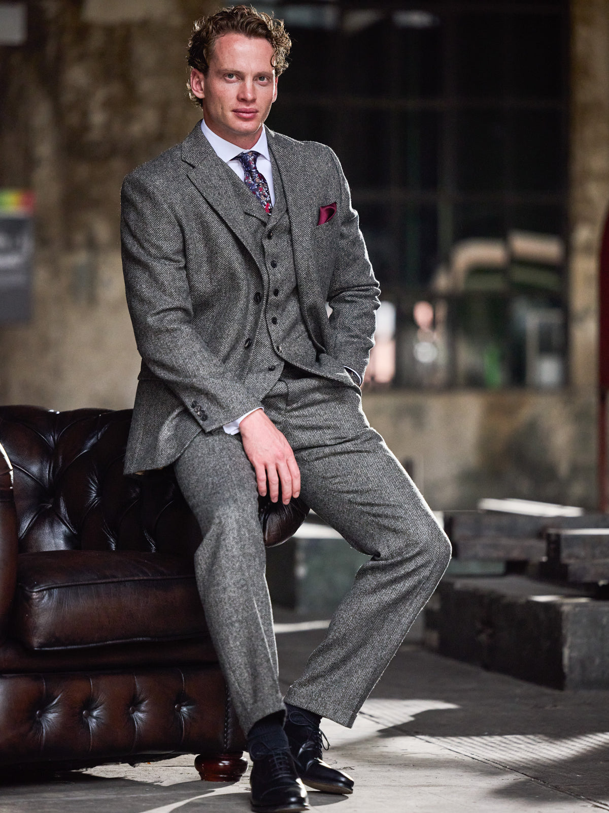 Tweed-Anzug Dark Grey mit Fischgrät aus Moon Tweed, Dreiteiler getragen, sitzend — John Crocket