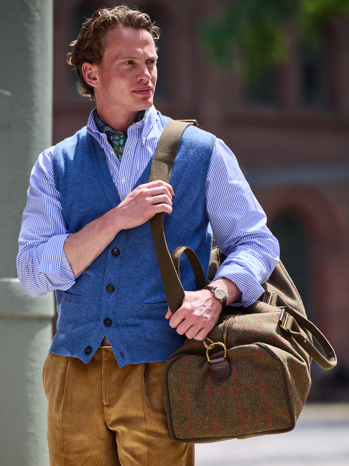 Weekender aus Lovat Tweed in Olive am Schulterriemen getragen, Fensterkaro und Lederlaschen im Detail – John Crocket