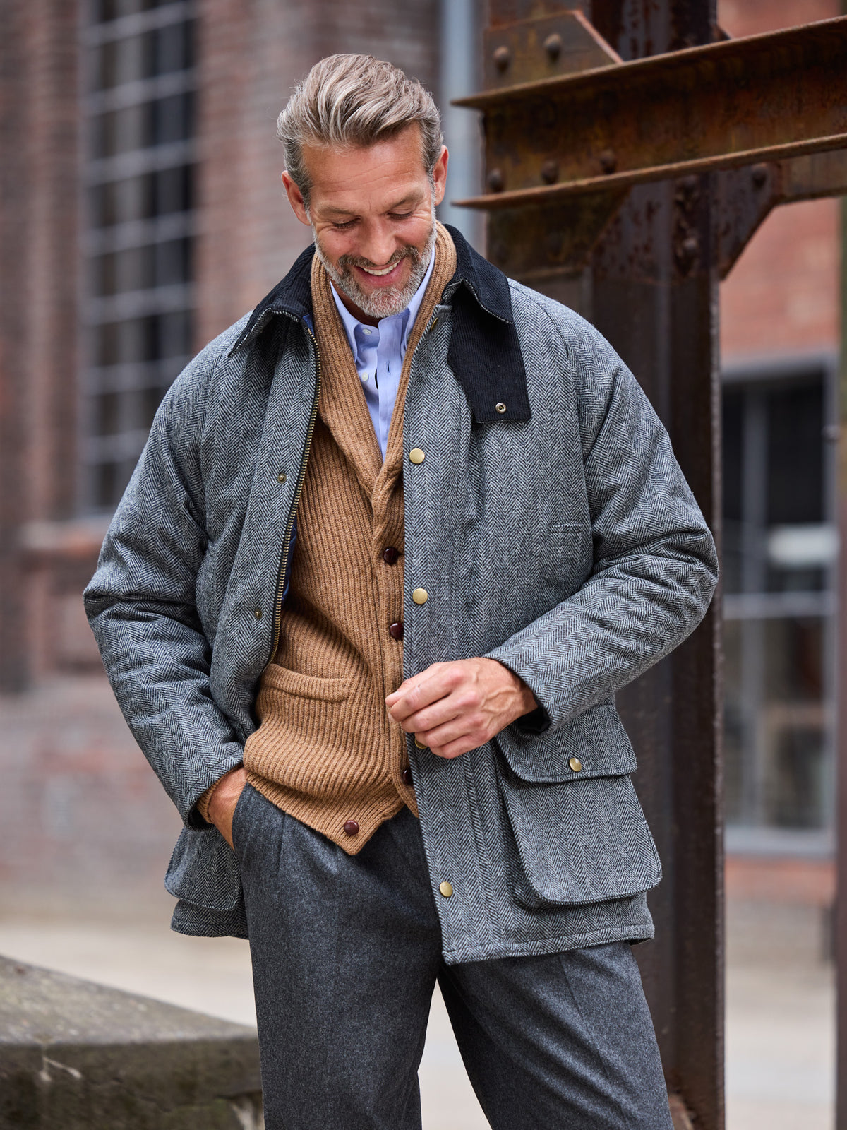 Oxford Jacke Fischgrät Moon Tweed Dark Grey am Model zu Strickjacke und grauer Hose — John Crocket
